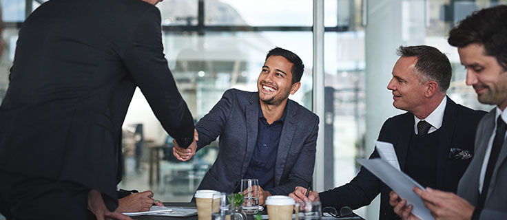 business man shakes hand during meeting.