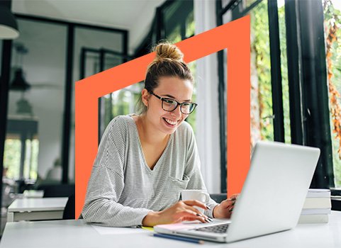 Girl with glasses smiling at white laptop.