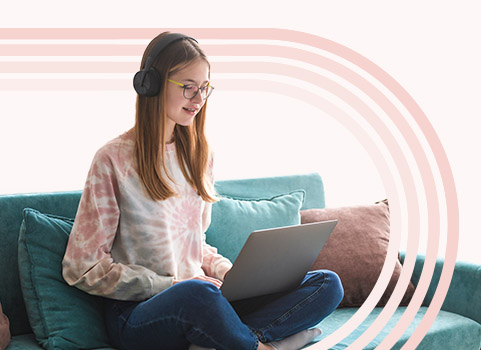 Teen girl on teal couch studying on laptop.