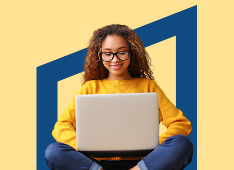 Girl in yellow sweater and glasses using laptop.