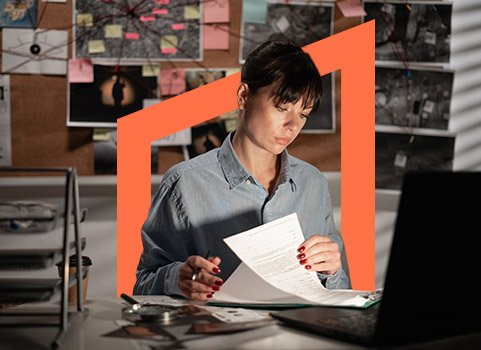 Woman reading through paperwork in office.