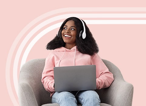 woman smiling with laptop and headphones.