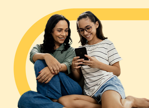 mom and daughter smiling looking at cell phone.