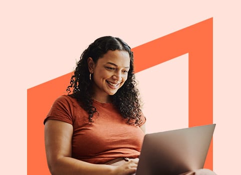 woman in an orange shirt working on a laptop.