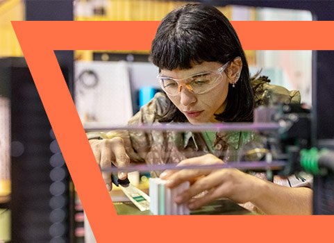 Woman in safety goggles working with 3D printing.