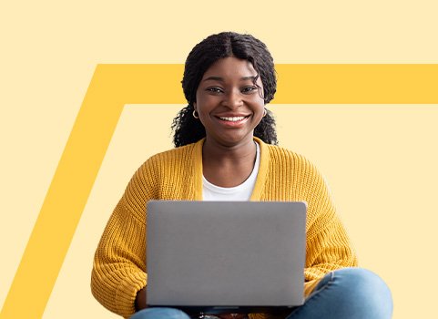 Girl in yellow sweater using silver laptop.