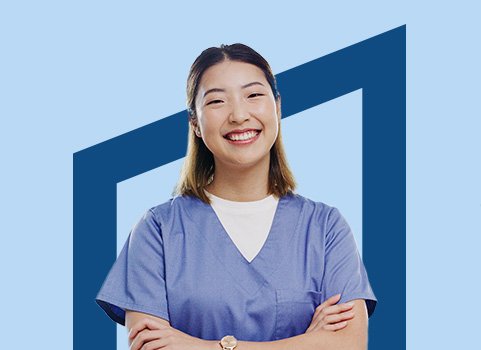 Woman in blue scrubs smiling on blue background.