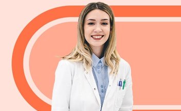pharmacy technician in white coat on orange background.