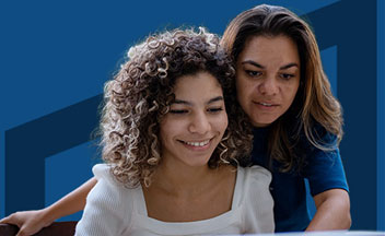 mom and daughter in front of laptop on dark blue background.