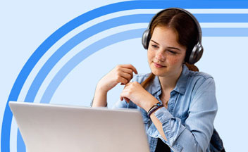 High school student wearing headphones while watching a lesson on their laptop.