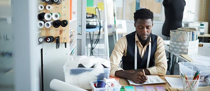 clothing designer working at a desk.