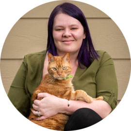 Kira, Penn Foster Vet Tech graduate, with orange cat.